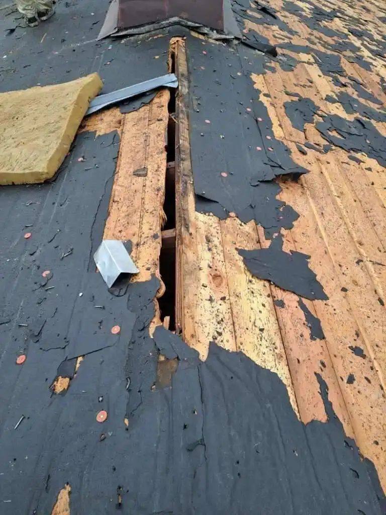 Roof replacement in progress with new underlayment and shingles being installed