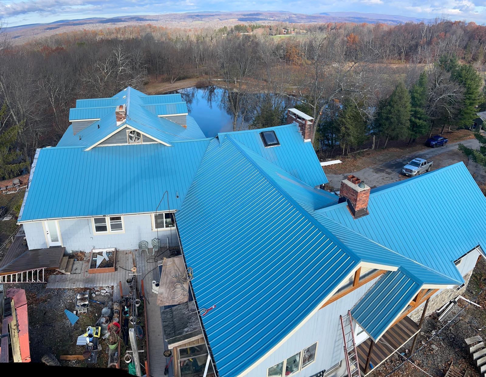 Aerial view of a completed blue standing seam metal roof